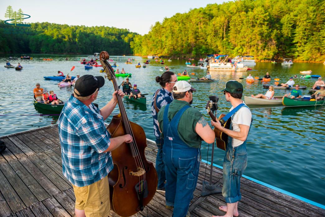Musicians playing music on a dock by Philpott Lake